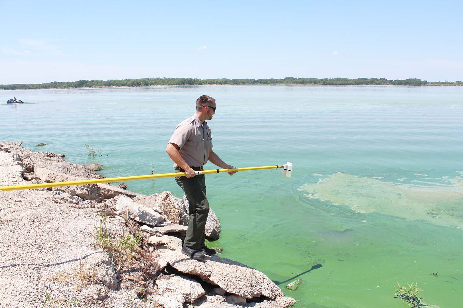 A U.S. Army Corps of Engineers ranger samples at Milford Lake, Kansas, during a harmful algal bloom event in the summer of 2021. (USACE photo by Kansas City District) A U.S. Army Corps of Engineers ranger samples at Milford Lake, Kansas, during a harmful algal bloom event in the summer of 2021. (USACE photo by Kansas City District)